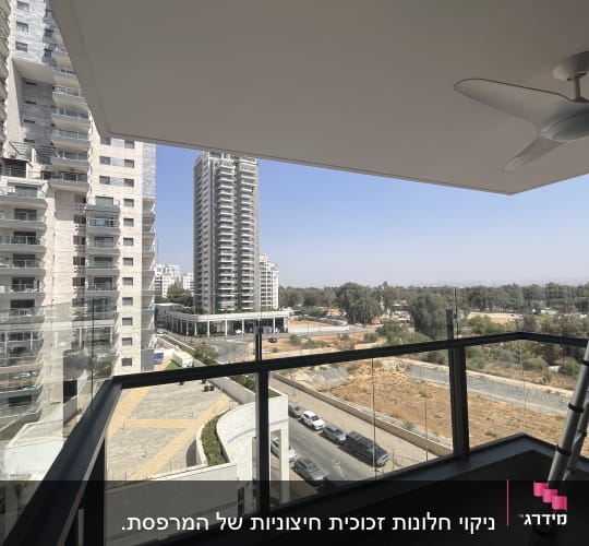 ניקוי חלונות זכוכית חיצוניות של המרפסת.